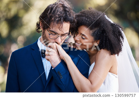 Wedding, kiss on hand and happy couple outdoor for marriage celebration event together with commitment. Interracial man and woman at ceremony with trust, partnership and respect with smile from bride Wedding, kiss on hand and happy couple outdoor for marriage celebration event together with commitment. Interracial man and woman at ceremony with trust, partnership and respect with smile from bride 130599757