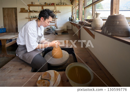 一名年輕人正在使用陶輪製作陶器 130599776