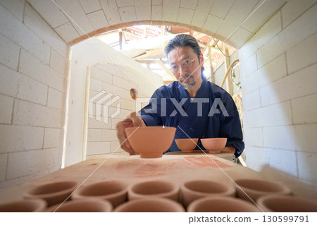 A potter working in the kiln 130599791