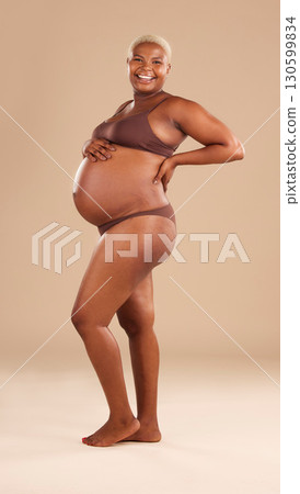 Pregnant, portrait and black woman isolated on studio background for beauty, skincare and happy abdomen health. Underwear, body and african model or person pregnancy for wellness, care and self love Pregnant, portrait and black woman isolated on studio background for beauty, skincare and happy abdomen health. Underwear, body and african model or person pregnancy for wellness, care and self love 130599834