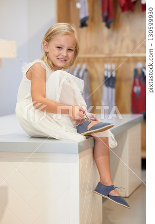 Little girl, portrait smile and tying shoe lace on table in retail store for cute toddler fashion or style. Happy adorable child smiling for shopping, trying out or fitting on shoes at clothing shop Little girl, portrait smile and tying shoe lace on table in retail store for cute toddler fashion or style. Happy adorable child smiling for shopping, trying out or fitting on shoes at clothing shop 130599930