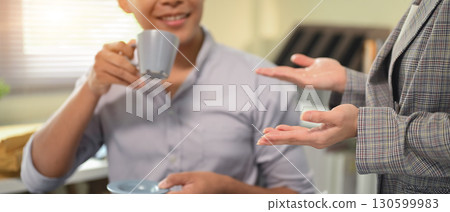 Close up of two coworkers collaborating and sharing ideas in a modern office Close up of two coworkers collaborating and sharing ideas in a modern office 130599983