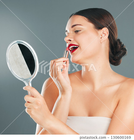 Red lipstick, mirror and woman face with smile happy with cosmetics and makeup brush. Mouth, female and beauty model looking at reflection with cosmetic tool with studio background and lips product Red lipstick, mirror and woman face with smile happy with cosmetics and makeup brush. Mouth, female and beauty model looking at reflection with cosmetic tool with studio background and lips product 130600169