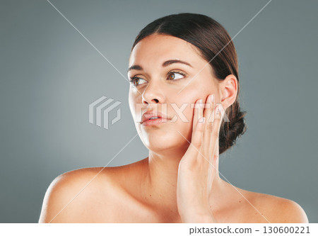 Beauty, skincare and woman touching face in studio for wellness, clean facial and cosmetics. Young female model, aesthetic makeup and dermatology from healthy shine, natural glow and salon results 130600221