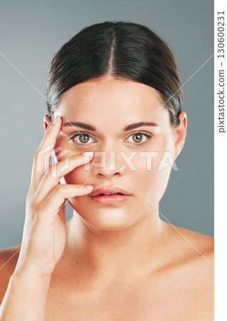 Woman, beauty and portrait in studio for skincare, wellness and facial cosmetics. Young female model touching face, aesthetic makeup and dermatology from healthy shine, natural glow and salon results 130600231