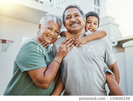 Piggyback, love and portrait of grandparents with a child in the backyard of their family home. Happiness, smile and elderly man and woman in retirement bonding with grandson outdoor their house. Piggyback, love and portrait of grandparents with a child in the backyard of their family home. Happiness, smile and elderly man and woman in retirement bonding with grandson outdoor their house. 130600249