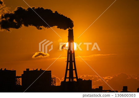Factory chimneys overlapping with the rising sun Factory chimneys overlapping with the rising sun 130600303