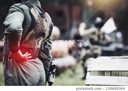 Pain, inflammation and person at paint ball with a back injury, medical emergency and accident in game. Symptom, swollen and man with an injured, sore and painful body after a fun competition 130600364