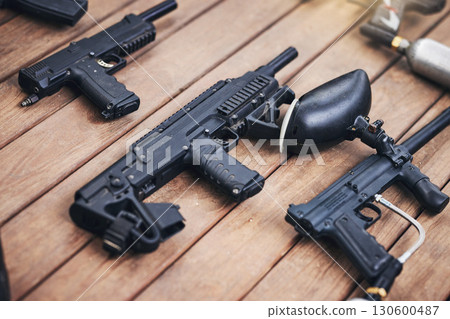 Paintball, gun and equipment on a wooden table or surface from above for sports, recreation or fun. Team sport, safety and paint ball with weapons ready for a competitive game or match outdoor Paintball, gun and equipment on a wooden table or surface from above for sports, recreation or fun. Team sport, safety and paint ball with weapons ready for a competitive game or match outdoor 130600487