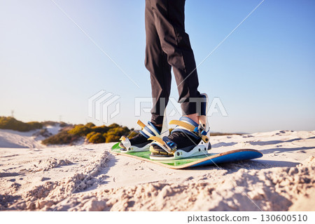 Sandboard, sports and athlete in the desert sand with hills for exercise, competition or training. Fitness, travel and man on a board in a dune for a workout while on vacation or adventure in Dubai. 130600510