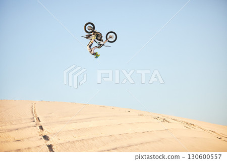 Motorcycle, jump and sports athlete in desert, dirt bike rally outdoor with extreme sport stunt, power and action. Nature, adventure and freedom, fitness challenge and biker person, mockup and travel Motorcycle, jump and sports athlete in desert, dirt bike rally outdoor with extreme sport stunt, power and action. Nature, adventure and freedom, fitness challenge and biker person, mockup and travel 130600557