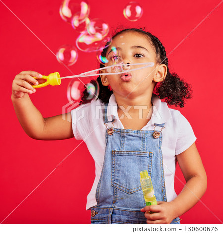 Little girl, playing or blowing bubbles on isolated red background in hand eye coordination, activity or fun game. Child, kid or youth with soap, wand or toy in studio for breathing development skill Little girl, playing or blowing bubbles on isolated red background in hand eye coordination, activity or fun game. Child, kid or youth with soap, wand or toy in studio for breathing development skill 130600676