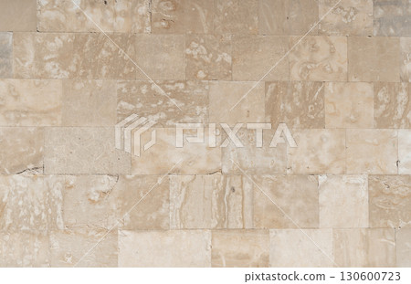 Antique ancient stone wall masonry texture background. Old wall made of beige stone blocks  130600723