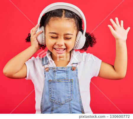 Dancing, child and headphones for music, fun radio and girls podcast on isolated red background and studio. Smile, happy and energy kid listening to dance audio, sound and streaming media on backdrop Dancing, child and headphones for music, fun radio and girls podcast on isolated red background and studio. Smile, happy and energy kid listening to dance audio, sound and streaming media on backdrop 130600772