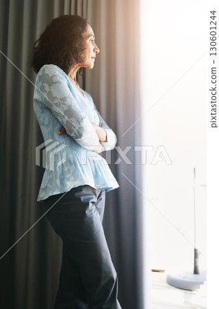 Window, depression and senior woman with stress, burnout and isolated in home, anxiety or arms crossed. Mature female, mental health or lady with doubt, anxious or thinking with bad news or depressed Window, depression and senior woman with stress, burnout and isolated in home, anxiety or arms crossed. Mature female, mental health or lady with doubt, anxious or thinking with bad news or depressed 130601244