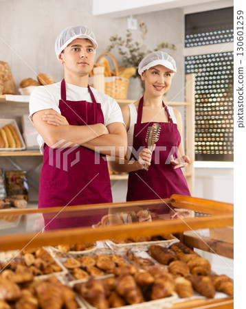 Young sellers standing in bake house, ready to greet customers Young sellers standing in bake house, ready to greet customers 130601259