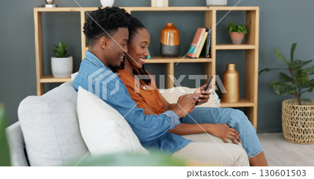 Internet, technology and couple with phone on sofa in living room. Black man, young woman and a banking app, online shopping or social media on a mobile on a couch at home for communication and relax Internet, technology and couple with phone on sofa in living room. Black man, young woman and a banking app, online shopping or social media on a mobile on a couch at home for communication and relax 130601503