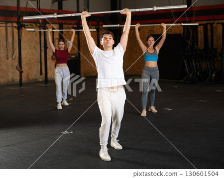 Man doing an exercise with a barbell Man doing an exercise with a barbell 130601504