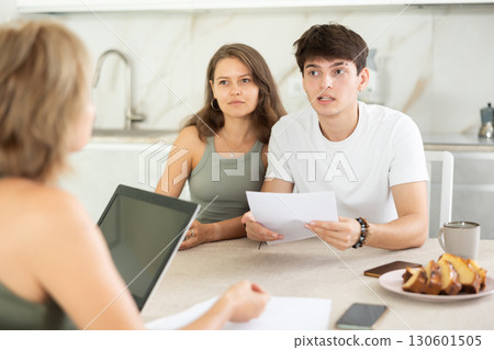 Married couple of clients listen attentively and intently to woman of seller Married couple of clients listen attentively and intently to woman of seller 130601505