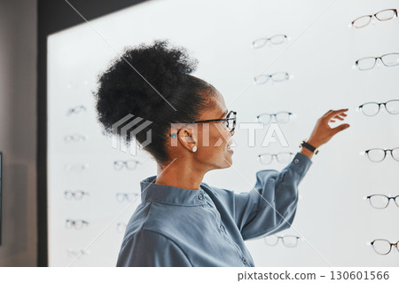 Vision, optometry and black woman shopping for glasses, spectacles or frames at optical store. Eye care, ophthalmology and happy female customer with choice or decision for retail lenses or eyewear. Vision, optometry and black woman shopping for glasses, spectacles or frames at optical store. Eye care, ophthalmology and happy female customer with choice or decision for retail lenses or eyewear. 130601566