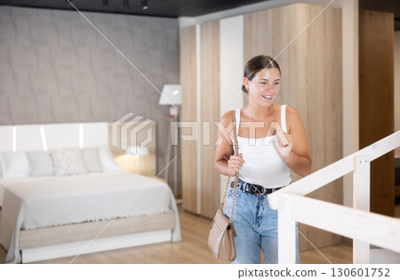 Young girl choosing convenient mattress in furniture shop Young girl choosing convenient mattress in furniture shop 130601752