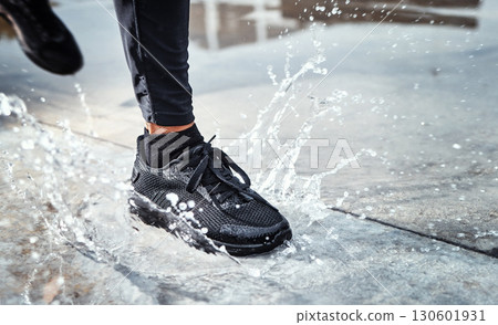 Feet splash water in street, person running in the rain and shoes in puddle of Seattle road for outdoor cardio. Runner training for marathon, step on wet ground and moving fast for fitness exercise Feet splash water in street, person running in the rain and shoes in puddle of Seattle road for outdoor cardio. Runner training for marathon, step on wet ground and moving fast for fitness exercise 130601931