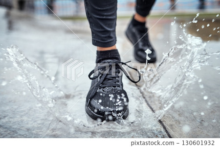 Shoes of person running in the rain, feet splash water in puddle and outdoor cardio in Seattle road. Runner training for marathon, step on wet ground and legs moving fast for fitness exercise Shoes of person running in the rain, feet splash water in puddle and outdoor cardio in Seattle road. Runner training for marathon, step on wet ground and legs moving fast for fitness exercise 130601932