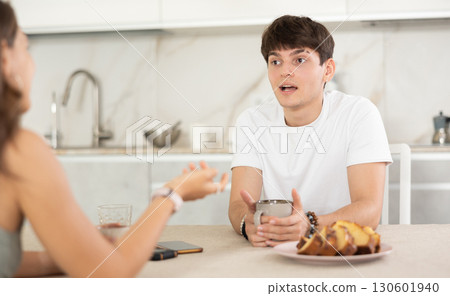 Young couple drinking tea and talking in kitchen 130601940