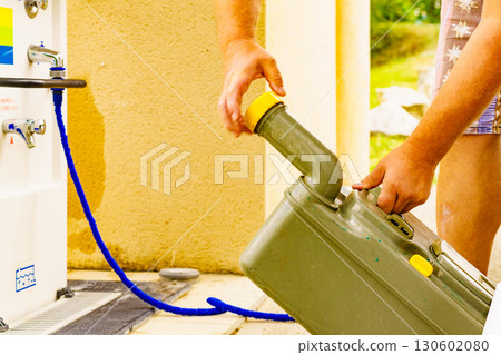 Man emptying caravan tank toilet cassette in dump station. Man emptying caravan tank toilet cassette in dump station. 130602080