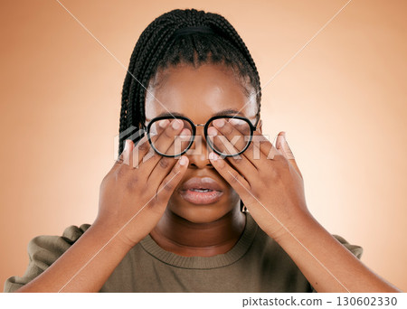Hands, eyes and glasses with a black woman in studio on a beige background covering her face. Vision, blind and cover with a female indoor to promote eye care or health for the optometry industry Hands, eyes and glasses with a black woman in studio on a beige background covering her face. Vision, blind and cover with a female indoor to promote eye care or health for the optometry industry 130602330