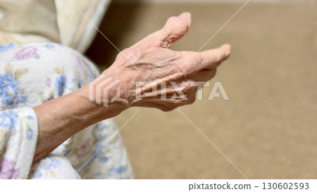 Elderly woman in pajamas stretching out her hand 130602593