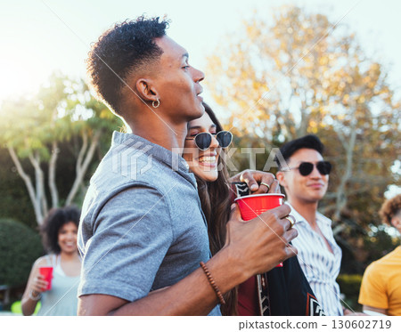 Drinks, party and a couple of friends outdoor to celebrate at festival, concert or summer social event. Diversity young men and women crowd while happy, hug and drinking alcohol while listening 130602719