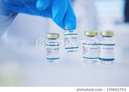 Monkeypox vaccine, hands and virus vials for safety, healthcare medicine and immunity in laboratory. Closeup vaccination, liquid bottle and drugs for protection, medical wellness and pharma research 130602743