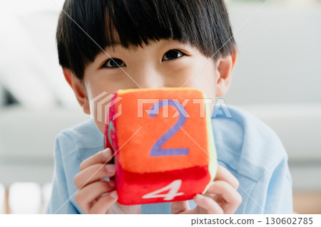Boy playing with number dice Boy playing with number dice 130602785