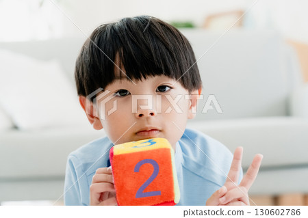 Boy playing with number dice Boy playing with number dice 130602786