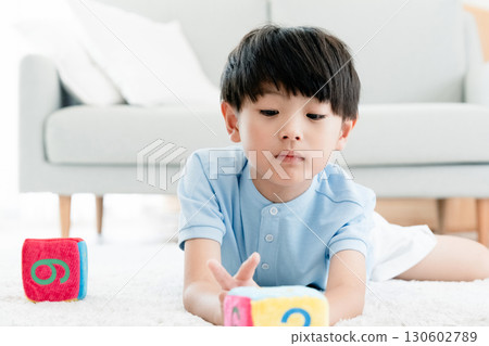 Boy playing with number dice Boy playing with number dice 130602789