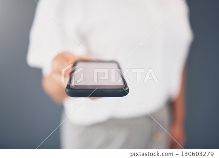 Mockup, showing and hand of a woman with a phone screen isolated on a grey studio background. Contact, networking and employee giving a mobile for communication, call or message on a backdrop 130603279