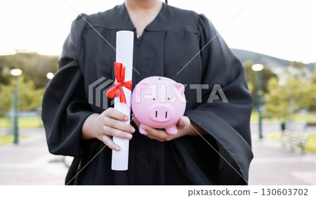 Piggy bank, saving and university diploma in hands of woman graduate with education scroll. Study paper, scholarship and college trust fund of a woman hand at college event with money for future Piggy bank, saving and university diploma in hands of woman graduate with education scroll. Study paper, scholarship and college trust fund of a woman hand at college event with money for future 130603702