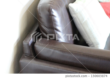 Dust accumulated on the corners of a leather sofa. Brown sofa. 130603874