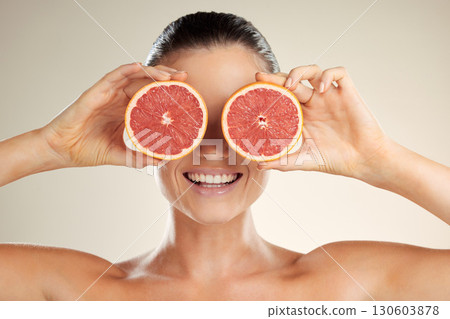 Beauty, skincare and woman cover grapefruit for natural skin dermatology or cosmetic product. Vitamin c fruit on happy face aesthetic model in studio for sustainable self care for health and wellness Beauty, skincare and woman cover grapefruit for natural skin dermatology or cosmetic product. Vitamin c fruit on happy face aesthetic model in studio for sustainable self care for health and wellness 130603878