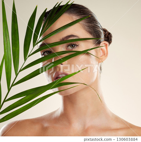Woman, face and leaf for natural skincare, cosmetics or healthy facial beauty treatment. Portrait of beautiful female with organic plant, leafs or nature wellness for self love, care or perfect skin 130603884