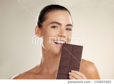 Beauty portrait, eating and woman with chocolate bar, junk food or dessert for sugar sweets, candy snack or cheat meal. Cosmetics makeup, skincare and hungry model with cacao product for antioxidants Beauty portrait, eating and woman with chocolate bar, junk food or dessert for sugar sweets, candy snack or cheat meal. Cosmetics makeup, skincare and hungry model with cacao product for antioxidants 130603885