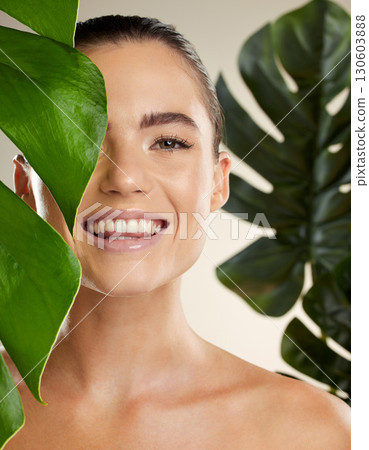 Beauty, skincare and woman portrait with green plant for natural skin dermatology cosmetic product. Happy face of aesthetic model in studio for sustainable glow or makeup for health and wellness Beauty, skincare and woman portrait with green plant for natural skin dermatology cosmetic product. Happy face of aesthetic model in studio for sustainable glow or makeup for health and wellness 130603888