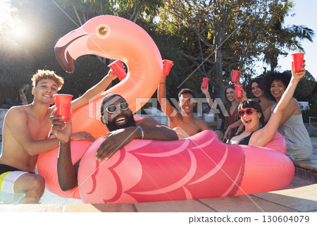 Beer, pool party and friends on flamingo, having fun and partying on new year. Summer celebration, water event or group portrait of drunk funny people laughing with alcohol, swimming or float on bird Beer, pool party and friends on flamingo, having fun and partying on new year. Summer celebration, water event or group portrait of drunk funny people laughing with alcohol, swimming or float on bird 130604079