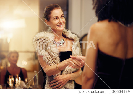 Success, handshake or women in a party shaking hands for partnership agreement at social event. Thank you, congratulations or happy people greeting or meeting at luxury dinner gala for winning a deal 130604139