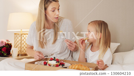 Mother, child and breakfast in the bed together on mothers day, morning and talking in home and eating food or pancakes. Girl, mom and bite of healthy strawberry, croissant or bonding in bedroom Mother, child and breakfast in the bed together on mothers day, morning and talking in home and eating food or pancakes. Girl, mom and bite of healthy strawberry, croissant or bonding in bedroom 130604210