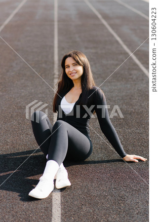 Athletic Woman Sitting On Sunny Track Athletic Woman Sitting On Sunny Track 130604223