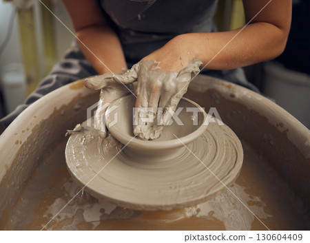 Clay, pottery or hands in designer workshop working on an artistic cup or mug mold in small business studio. Hand of creative artist or worker manufacturing handicraft products in sculpture process Clay, pottery or hands in designer workshop working on an artistic cup or mug mold in small business studio. Hand of creative artist or worker manufacturing handicraft products in sculpture process 130604409