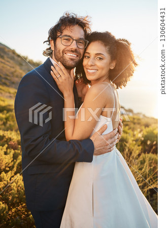 Portrait, interracial and bride with groom for wedding at sunset in nature, hug and celebrate love and relationship. Face, couple and marriage by black woman and man smile, hug and happy Portrait, interracial and bride with groom for wedding at sunset in nature, hug and celebrate love and relationship. Face, couple and marriage by black woman and man smile, hug and happy 130604431