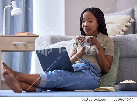 Happy, black woman on floor and laptop to relax, smile and peace in living room, connection and streaming. African American female, lady and device for movies, funny videos and happiness in lounge 130604544